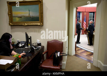 Präsident Barack Obama spricht mit gen. Martin Dempsey, Vorsitzende des Generalstabs im Oval Office, 11. März 2015. ferial govashiri, persönlicher Referent des Präsidenten an Ihrem Schreibtisch in der äußeren Oval Office arbeitet. (Offizielle weiße Haus Foto von Pete Souza) diese offiziellen Weißen Haus Foto steht zur Verfügung, die nur für die Veröffentlichung von Nachrichten Organisationen und/oder für den persönlichen Gebrauch drucken durch das Subjekt (s) des Fotos gemacht. Das Foto darf nicht in irgendeiner Weise manipuliert werden und dürfen nicht in kommerziellen oder politischen Materialien, Anzeigen, E-Mails, Produkte verwendet werden, Werbeaktionen, die in Stockfoto