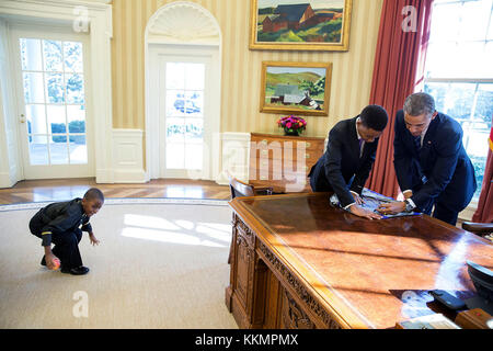 Präsident Barack Obama unterzeichnet ein Plakat für die 13-jährige Studentin Vidal chastanet, der auf der "Menschen von New York' Blog erschien, wie sein 6-jähriger Bruder Alden st. Marie spielt im Oval Office links, Feb. 5, 2015. (Offizielle weiße Haus Foto von Pete Souza) diese offiziellen Weißen Haus Foto steht zur Verfügung, die nur für die Veröffentlichung von Nachrichten Organisationen und/oder für den persönlichen Gebrauch drucken durch das Subjekt (s) des Fotos gemacht. Das Foto darf nicht in irgendeiner Weise manipuliert werden und dürfen nicht in kommerziellen oder politischen Materialien, Anzeigen, E-Mails, Produkte verwendet werden, Werbeaktionen, die in jeder w Stockfoto