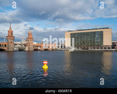 Anzeigen aus Berlin-Kreuzberg über die Spree mit farbigen Boje auf die Oberbaumbrücke und die Zentrale eines großen Musik Label in Bewölkt - sonniges Wetter. Stockfoto