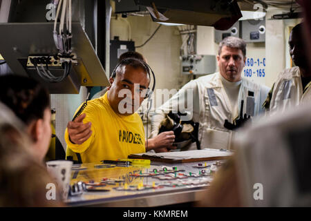 BETRIEBSBEREICH der 5. US-FLOTTE (Nov 28, 2017) Lt. Cmdr. Oscar Flores, Flugzeugabfertigungsoffizier, bewegt Flugzeuge auf einem maßstabsgemaßstätigen Modell des Flugdecks an Bord des Flugzeugträgers USS Theodore Roosevelt (CVN 71). Theodore Roosevelt und seine Carrier-Streikgruppe werden in den 5. Flottenbereich der USA eingesetzt, um die Sicherheit der Seeschifffahrt zu unterstützen, um Verbündete und Partner zu beruhigen und die Freiheit der Schifffahrt und den freien Handel in der Region zu bewahren. (USA Navy Foto von Mass Communication Specialist 3rd Class Alex Perlman/veröffentlicht) Stockfoto