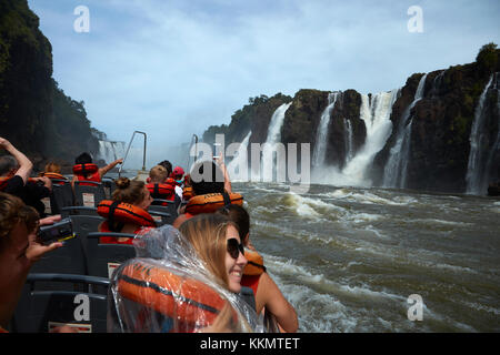 Touristen auf dem Boot, das unter Iguazu Falls, Argentinien, Südamerika geht Stockfoto