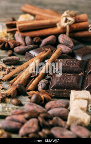 Dunkle Schokolade mit Kakaobohnen, Zimt und Anis über Holz- Hintergrund. siehe Serie. Stockfoto