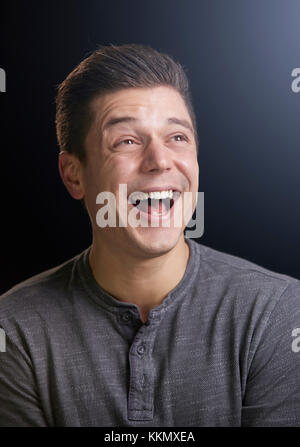 Lachende junge Mann suchen, vertikale Portrait Stockfoto