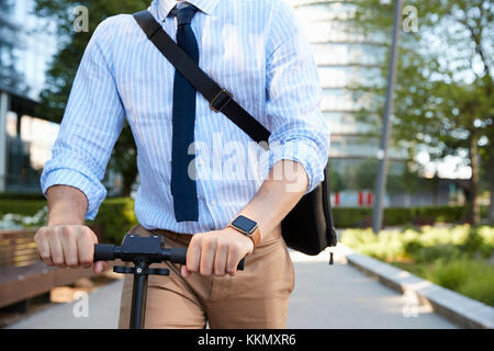 Nahaufnahme von Geschäftsmann Pendeln zur Arbeit bei Scooter Stockfoto