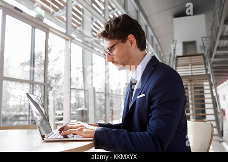 Young Professional Mann mit Laptop, in der Nähe Stockfoto