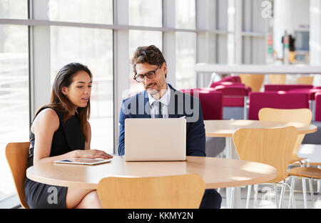 Geschäftsfrau und Geschäftsmann Blick auf laptop Stockfoto