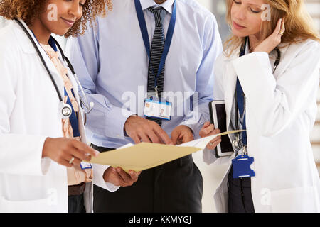 Drei junge männliche und weibliche Ärzte Beratung, mittlerer Abschnitt Stockfoto
