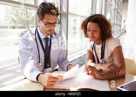 Männliche und weibliche Oberärzte lesen Patienten Anmerkungen Stockfoto