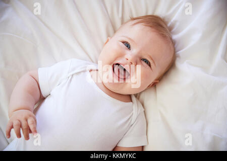 Overhead Shot von Happy Baby Boy liegend auf Bett der Eltern Stockfoto