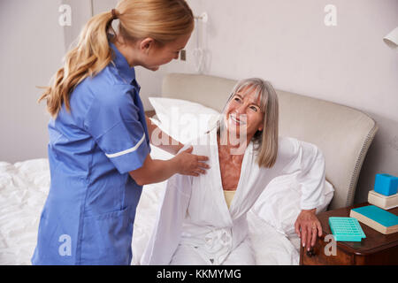 Krankenschwester Helfen ältere Frau aus dem Bett zu Hause besuchen Stockfoto