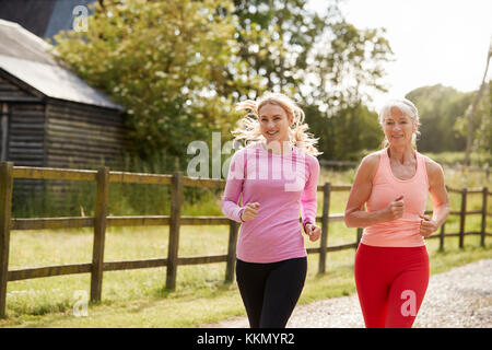 Junge und ältere Frauen genießen, laufen durch die Landschaft zusammen Stockfoto