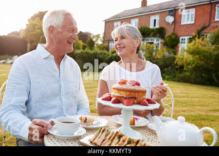 Rentnerehepaar genießen Nachmittagstee im Garten zu Hause Stockfoto