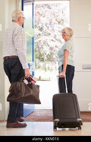 Senior Paar mit Gepäck Home verlassen für einen Urlaub Stockfoto