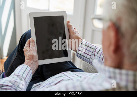 Ältere Menschen mit Tablet-PC zu Hause, über die Schulter sehen Stockfoto