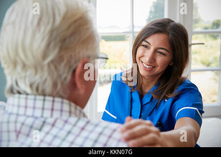 Blick über die Schulter der Krankenschwester zu Hause besuchen mit älterem Mann Stockfoto