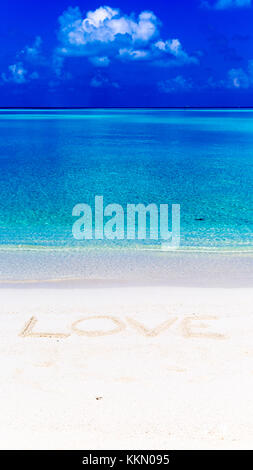 Wort Liebe auf Sand in Malediven geschrieben mit der Lagune im Hintergrund. Stockfoto