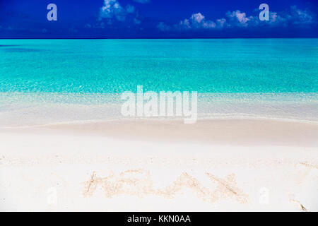 Wort entspannen Sie auf Sand in Malediven mit der Lagune im Hintergrund geschrieben. Stockfoto