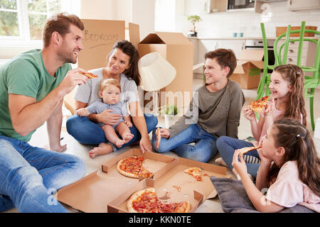 Familie feiern, Umzug in neues Zuhause mit Pizza Stockfoto