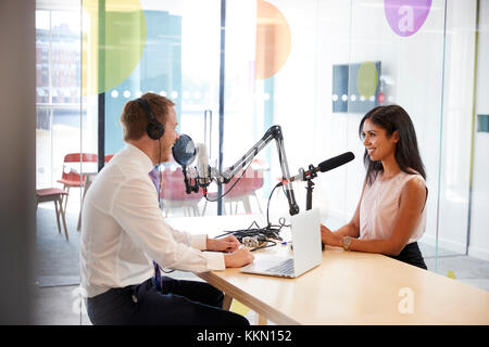 Junger Mann interviewt eine Frau im Radio Studio Stockfoto