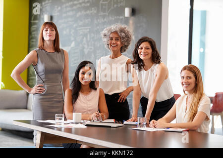 Fünf weiblichen Kollegen bei einem Arbeitstreffen lächelnd in die Kamera Stockfoto