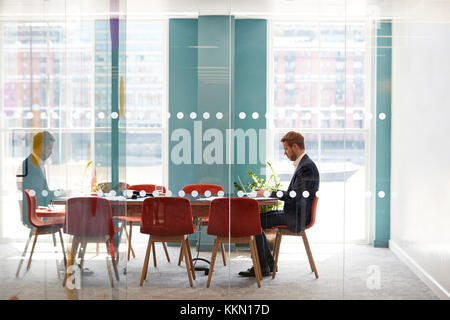 Junge Unternehmer allein in einem Büro Besprechungsraum arbeiten Stockfoto