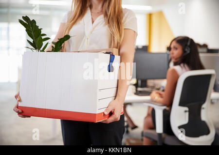 Feuerte weiblicher Angestellter Holding Box von Hab und Gut in einem Büro Stockfoto