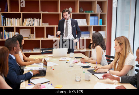 Junge männliche Manager stehen in einem Unternehmen Sitzungssaal Sitzung Stockfoto
