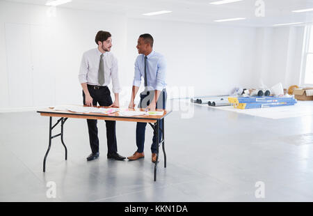Die Unternehmer über Pläne für Office interior design Stockfoto