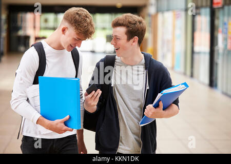 Zwei männliche Studenten lesen SMS auf Handy Stockfoto