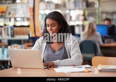 Reife weibliche Schüler Arbeiten am Laptop in der Hochschule Bibliothek Stockfoto