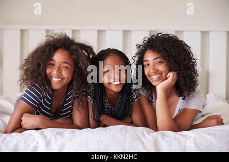 Portrait von drei Teenager Schwestern liegend auf Bett zu Hause Stockfoto