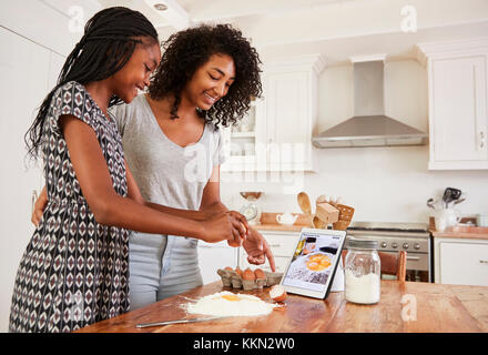 Jugendmädchen folgende Rezept auf digitalen Tablet Stockfoto