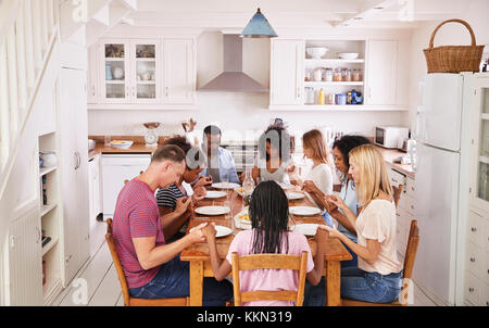 Zwei Familien sagen Gnade vor Zusammen essen Essen Stockfoto