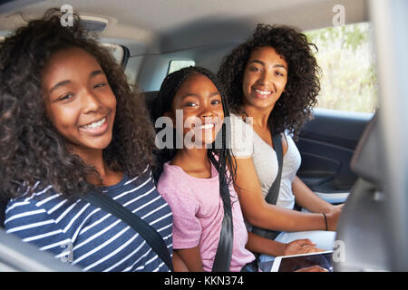 Porträt der Familie mit jugendlichen Kindern im Auto auf der Straße Reise Stockfoto