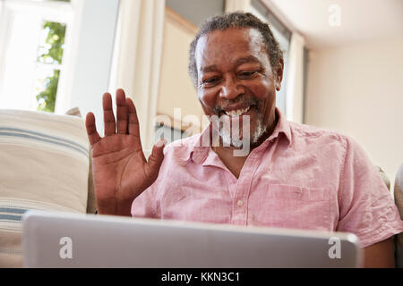 Älterer Mann mit Laptop zu verbinden Mit der Familie für Videokonferenz Stockfoto