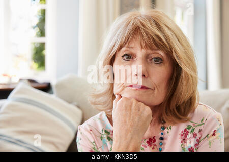 Portrait der älteren Frau auf Sofa, die unter Depressionen leiden Stockfoto