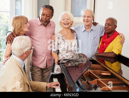 Gruppe von Senioren stehen von Piano und Gesang Stockfoto