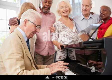 Gruppe von Senioren stehen von Piano und Gesang Stockfoto