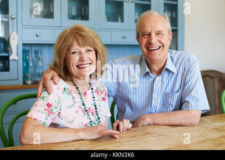 Portrait Of Smiling älteres paar zu Hause auf dem Sofa sitzen Stockfoto