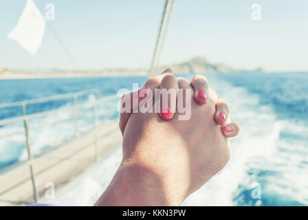 Mann und Frau, Hände halten, auf einer Yacht, die Freiheit und die Liebe zum Meer Stockfoto