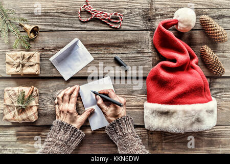 Konzeption: Weihnachten. Weihnachten Geschenke. Ein Mann schreibt einen Brief Grußkarten an Freunde und Familie. nach oben Ausblick Stockfoto