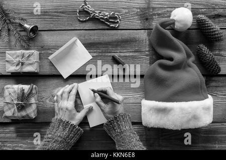 Konzeption: Weihnachten. Weihnachten Geschenke. Ein Mann schreibt einen Brief Grußkarten an Freunde und Familie. nach oben Ausblick Stockfoto