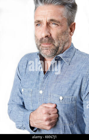 Studio geschossen von reifer Mann leiden mit Magenschmerzen Stockfoto