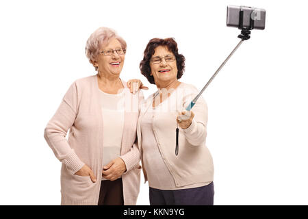 Zwei ältere Frauen, die einen selfie mit einem Stock auf weißem Hintergrund Stockfoto