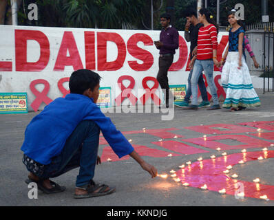 Kolkata, Indien. 01 Dez, 2017. Kinder Lampen auf rotem Band und Slogan, der bei einem sozialen Bewusstsein generation Programm für die Beseitigung der Stigmatisierung und Panik auf HIV/Aids anlässlich des Welt-AIDS-Tag am 1. Dezember Lit, 2017 in Kalkutta. Welt-AIDS-Tag am 01. Dezember jährlich beobachtet ist es, das Bewusstsein über HIV/Aids zu schärfen. Credit: saikat Paul/Pacific Press/alamy leben Nachrichten Stockfoto