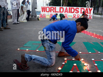 Kolkata, Indien. 01 Dez, 2017. Kinder Lampen auf rotem Band und Slogan, der bei einem sozialen Bewusstsein generation Programm für die Beseitigung der Stigmatisierung und Panik auf HIV/Aids anlässlich des Welt-AIDS-Tag am 1. Dezember Lit, 2017 in Kalkutta. Welt-AIDS-Tag am 01. Dezember jährlich beobachtet ist es, das Bewusstsein über HIV/Aids zu schärfen. Credit: saikat Paul/Pacific Press/alamy leben Nachrichten Stockfoto