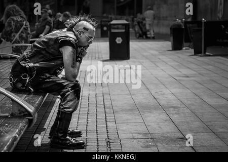 Punk Rocker saß in Piccadilly Gardens im Stadtzentrum von Manchester, England, Großbritannien Stockfoto