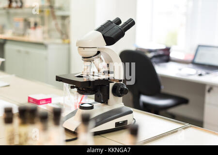 Mikroskop im Labor auf Hintergrund Tabelle mit Computer. Konzept: Research Lab Stockfoto