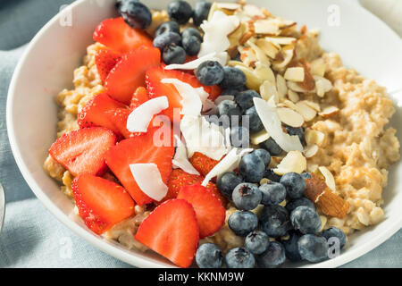 Gesunde, frische Erdbeeren Mandeln Haferflocken mit Heidelbeeren und Kokosnuss Stockfoto