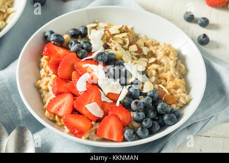 Gesunde, frische Erdbeeren Mandeln Haferflocken mit Heidelbeeren und Kokosnuss Stockfoto
